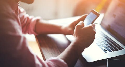 Man with smartphone and laptop