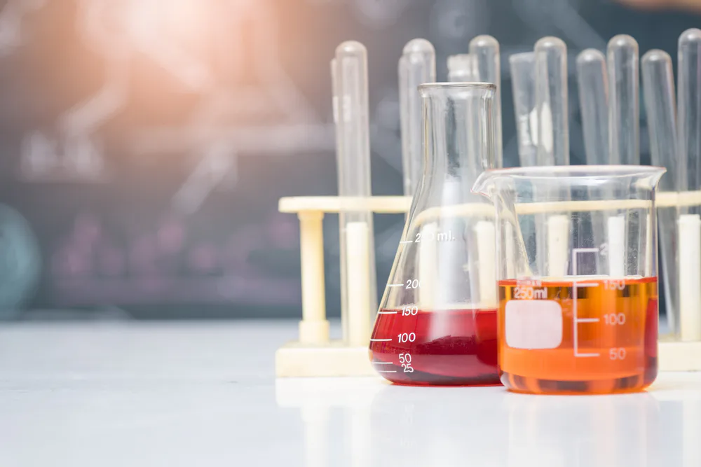 Wissenschaftliches Experiment Bechergläser mit oranger und roter Flüssigkeit
